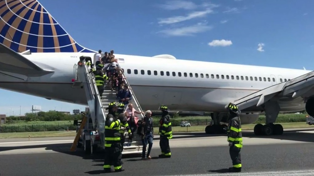 Firefighters help passengers disembark from a United Airlines passenger jet that skidded off the runway Saturday at Newark Liberty International Airport.
