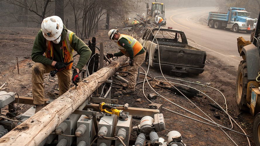 PG&E workers dissemble broken power lines after the Camp fire ripped through Paradise, CA, in November 2018.