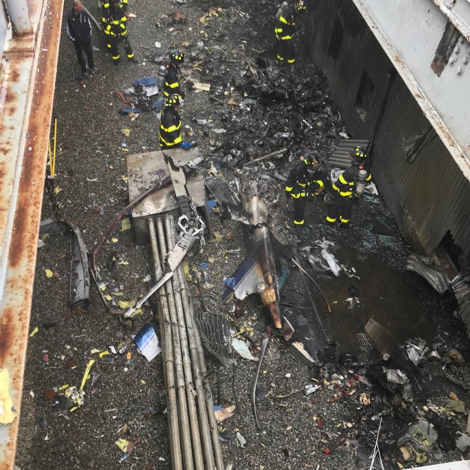 FDNY firefighters examine the site of a helicopter crash atop a Manhattan building Monday.
