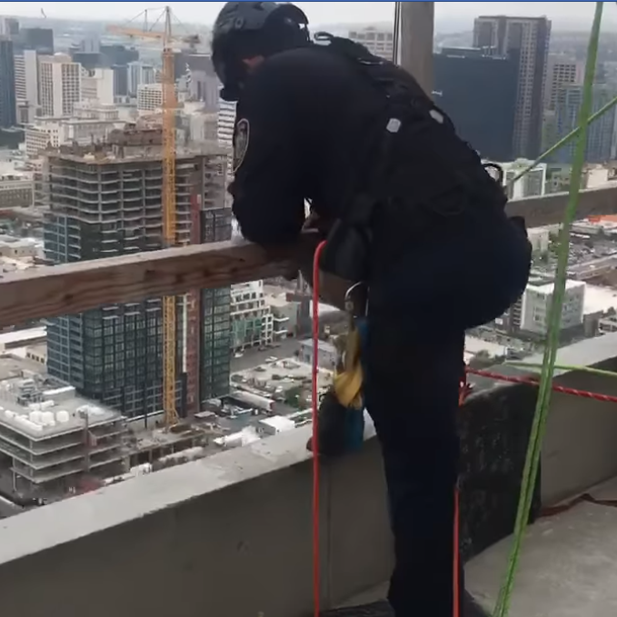 San Diego firefighters lowered themselves from the roof of a downtown building in order to rescue two construction workers trapped in a broken window washing lift Tuesday.