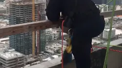 San Diego firefighters lowered themselves from the roof of a downtown building in order to rescue two construction workers trapped in a broken window washing lift Tuesday.