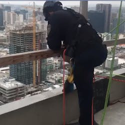 San Diego firefighters lowered themselves from the roof of a downtown building in order to rescue two construction workers trapped in a broken window washing lift Tuesday.