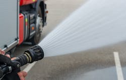 A fog nozzle would be best to attack a fire in close proximity to crews because it will hit a larger surface area with less effort.