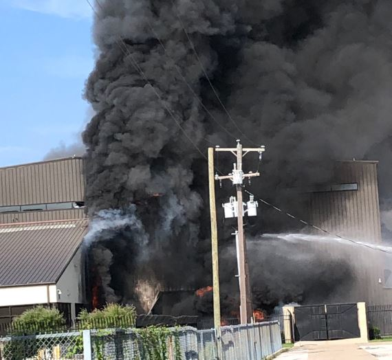 Smoke rises from a burning hangar after a small plane crashed at an airport in Addison, TX, killing all 10 people aboard on Sunday, June 30, 2019.