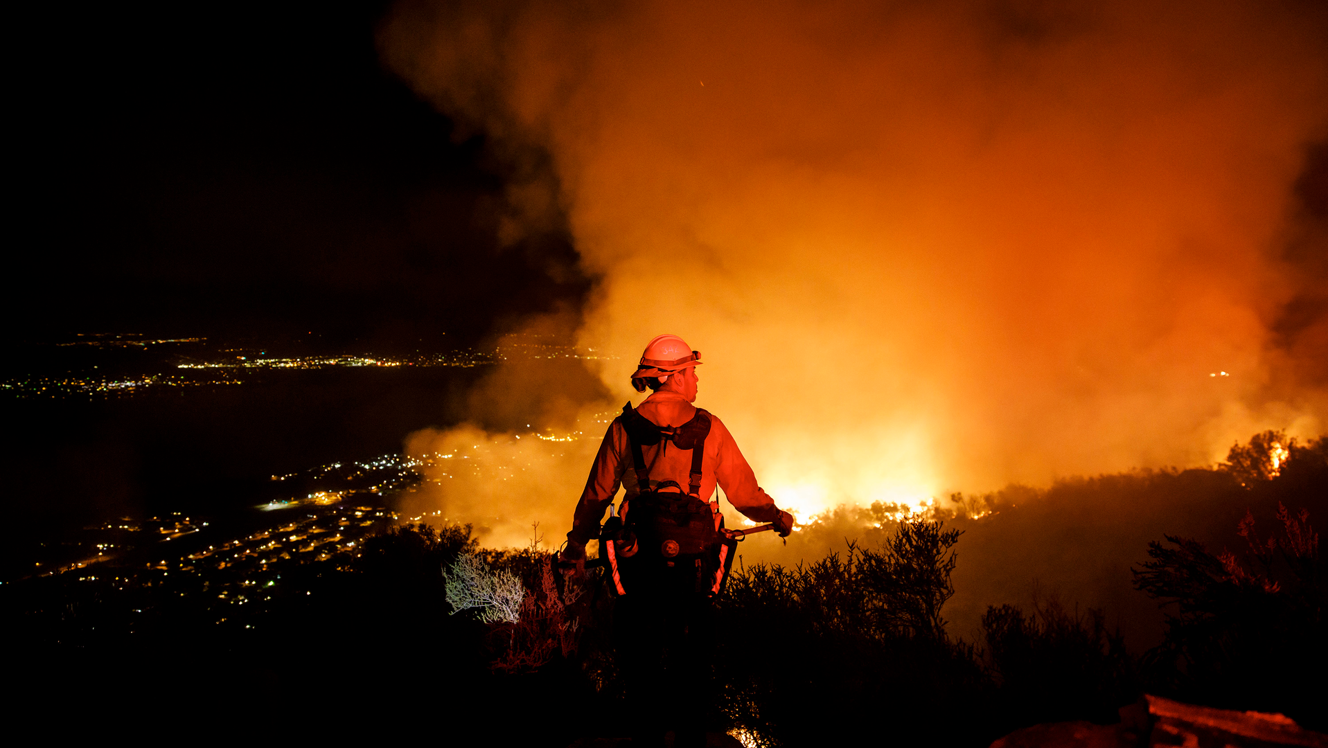 Firefighters watch for flare ups as they prevent the flames from the Holy Fire from crossing the Ortega Highway in Lake Elsinore, CA, in 2018.