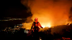 Firefighters watch for flare ups as they prevent the flames from the Holy Fire from crossing the Ortega Highway in Lake Elsinore, CA, in 2018.