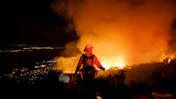 Firefighters watch for flare ups as they prevent the flames from the Holy Fire from crossing the Ortega Highway in Lake Elsinore, CA, in 2018.