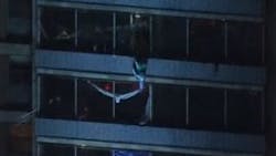 A man is seen scaling down a West Philadelphia high-rise to escape a trash chute fire in the 19-story building.