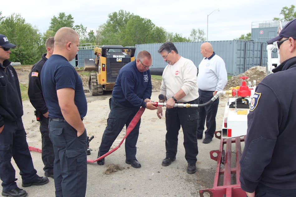 Ron Huffman, a lieutenant on the New Castle, IN, Fire Department, explaining fittings and how they connect together to Richmond hazmat personnel prior to an exercise.
