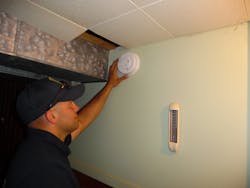 FF Nick Condidorio installing a smoke alarm during a campaign after a recent fire in the neighborhood.