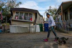 Carmen Rivera on a morning walk with her dog, Ash, passes by a mobile home dislodged in Torusdale Estates mobile home park by Thursday&apos;s 6.4 earthquake in Ridgecrest, CA, on Friday, July 5, 2019.