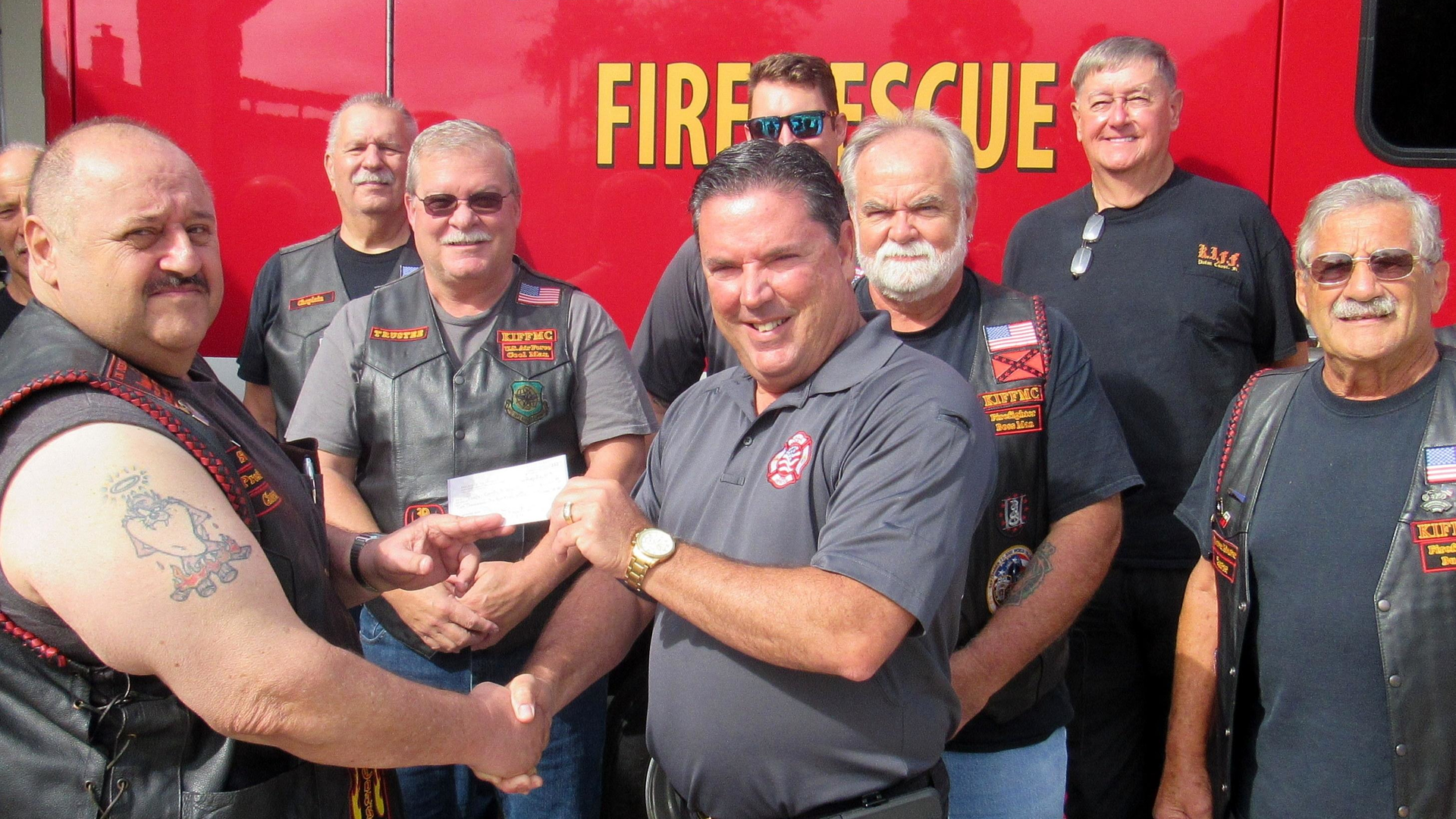 Knights of the Inferno Motorcycle Club Palm Coast chapter President Joe Vece presents Flagler County Fire Chief Don Petito with a check for $2,100 to help provide bulletproof vests and gear for emergency medical personnel.