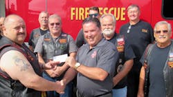 Knights of the Inferno Motorcycle Club Palm Coast chapter President Joe Vece presents Flagler County Fire Chief Don Petito with a check for $2,100 to help provide bulletproof vests and gear for emergency medical personnel.