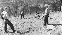 Investigators stand on the steep, barren north slope of Montana&apos;s Mann Gulch, where a wildfire killed 12 smokejumpers on Aug. 5, 1949.