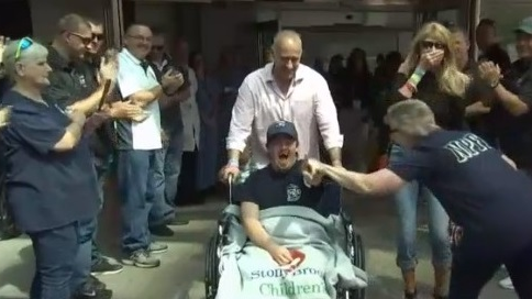 Tommy Spiotta, the 19-year-old son of a North Patchogue, NY, firefighter, receives cheers from his firehouse family after being released from the hospital Tuesday.