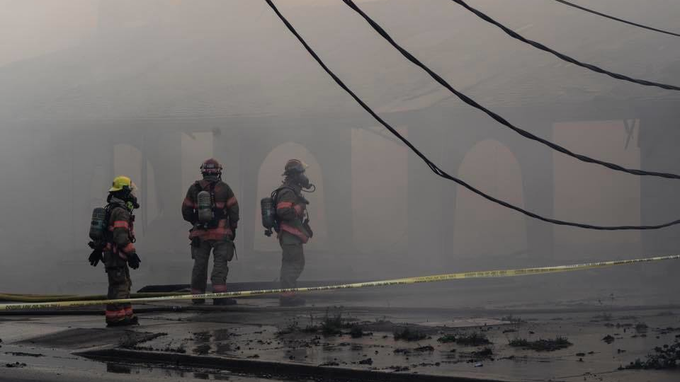 Firefighters battled a large grass fire that turned into a four-alarm blaze Monday.