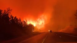 Drivers navigate through heavy smoke and flames caused by the Swan Lake wildfire near Sterling, AK. Drivers navigate through heavy smoke and flames caused by the Swan Lake wildfire near Sterling, AK.