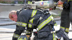A Trenton, NJ, firefighter changes a colleague's air bottle during a two-alarm fire in the city's Chambersburg neighborhood in this July 2016 file photo.