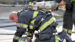 A Trenton, NJ, firefighter changes a colleague's air bottle during a two-alarm fire in the city's Chambersburg neighborhood in this July 2016 file photo. A Trenton, NJ, firefighter changes a colleague's air bottle during a two-alarm fire in the city's Chambersburg neighborhood in this July 2016 file photo.