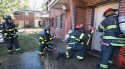 Firefighters prepare to enter a building for the Aggressive Fire Control, Flow Path, and VES Tactics HOT program.