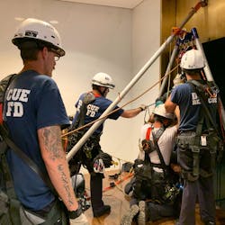 District of Columbia firefighters rescue two adults and a child from a stalled elevator at the Kennedy Center on Sunday.