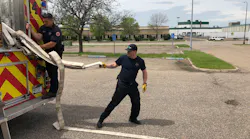 The layout firefighter pulls the largest loop to clear 100 feet of travel line from the hosebed.