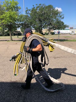 The nozzle firefighter shoulders the bundle and the first 50-foot stack of hose. Note the stack is flipped so if deploys off the top.