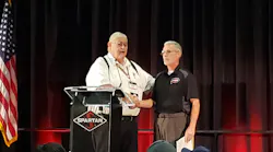 Bill Foster, left, vice president and founder of Spartan Motors, greets 2018 EVT of the Year Al Hasenfratz, right, as he prepares to give remarks at Spartan's Fire Truck Training Conference in Lansing, MI.