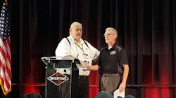 Bill Foster, left, vice president and founder of Spartan Motors, greets 2018 EVT of the Year Al Hasenfratz, right, as he prepares to give remarks at Spartan&apos;s Fire Truck Training Conference in Lansing, MI.