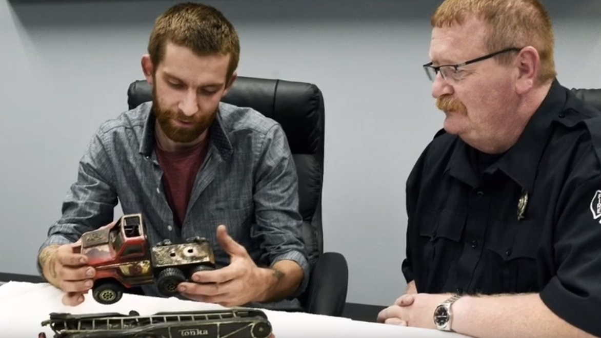 Monroe Township Fire Inspector Calvin Schmitt (right) sits with William Vantress as the two go through Scmitt's burned toys, some that had belonged to Vantress nearly 20 years ago.