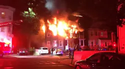 Two women were killed in a three-alarm fire Monday that also injured an Everett, MA, firefighter.