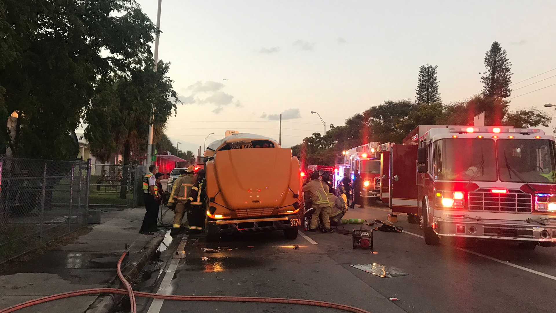 Miami firefighters cut through a school bus in order to free a trapped aide following a crash with a garbage truck Thursday morning.
