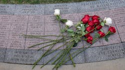 Roses from Firefighter Christopher Roy&apos;s family lay on a stone bearing his name at the Massachusetts Fallen Firefighters Memorial in Boston on Wednesday.