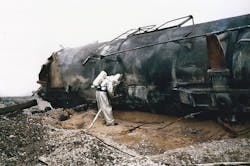 Firefighter in aluminized PPE pours water on remaining burning phosphorus inside the tank car. (Courtesy Miami Valley Fire District)
