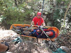 Firefighter participating in Advanced Wilderness Rope Rescue Course attends patient on a lower. Firefighter participating in Advanced Wilderness Rope Rescue Course attends patient on a lower.