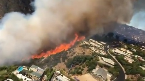 Video footage from Los Angeles County Fire Department Air Operations shows the view from the cockpit of a Firehawk helicopter used to drop water on the wildfire in the Pacific Palisades on Monday.