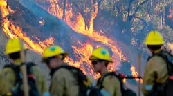 Firefighters keep an eye on the wildfire burning behind Olive View Medical Center in Sylmar, CA.