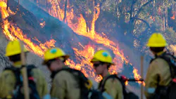 Firefighters keep an eye on the wildfire burning behind Olive View Medical Center in Sylmar, CA.