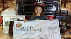 Ella Conroy, 6, shows off a check for the $30,007 raised by the South Buffalo, PA, Fire Department.