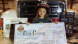 Ella Conroy, 6, shows off a check for the $30,007 raised by the South Buffalo, PA, Fire Department.