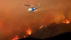 A Ventura County, CA, helicopter drops water on the fire raging through the Lang Ranch area in Thousand Oaks.
