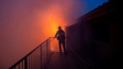 A Los Angeles County firefighter sprays water on a condominium engulfed by flames as the Saddleridge Fire burns on Oct. 11, 2019, in Porter Ranch, CA. A Los Angeles County firefighter sprays water on a condominium engulfed by flames as the Saddleridge Fire burns on Oct. 11, 2019, in Porter Ranch, CA.