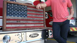 Panama City, FL, firefighter Daryl Paul stands with a flag he made from discarded fire hoses.