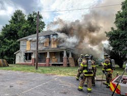 During live-fire training, the Salisbury, NC, Fire Department (SFD) appeared to have a close call. As the fire on the second floor intensified, a large piece of burning plywood flew from a window, narrowly missing a firefighter positioned at the bottom of a ladder.