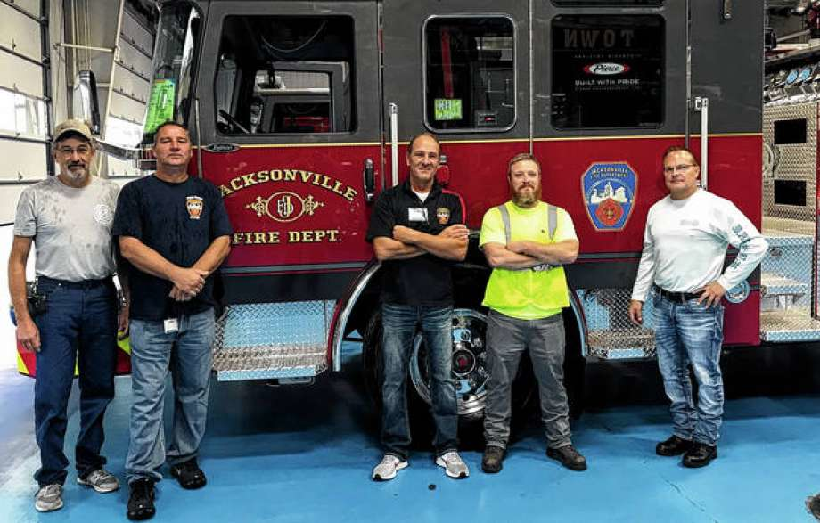 John Cooper (from left), the head mechanic for Jacksonville; Fire Captain Mike Martin; Fire Chief Doug Sills; Scott Mumford and Fire Captain Brian Nyberg view the city&rsquo;s new fire trucks at the Pierce Manufacturing factory in Wisconsin.