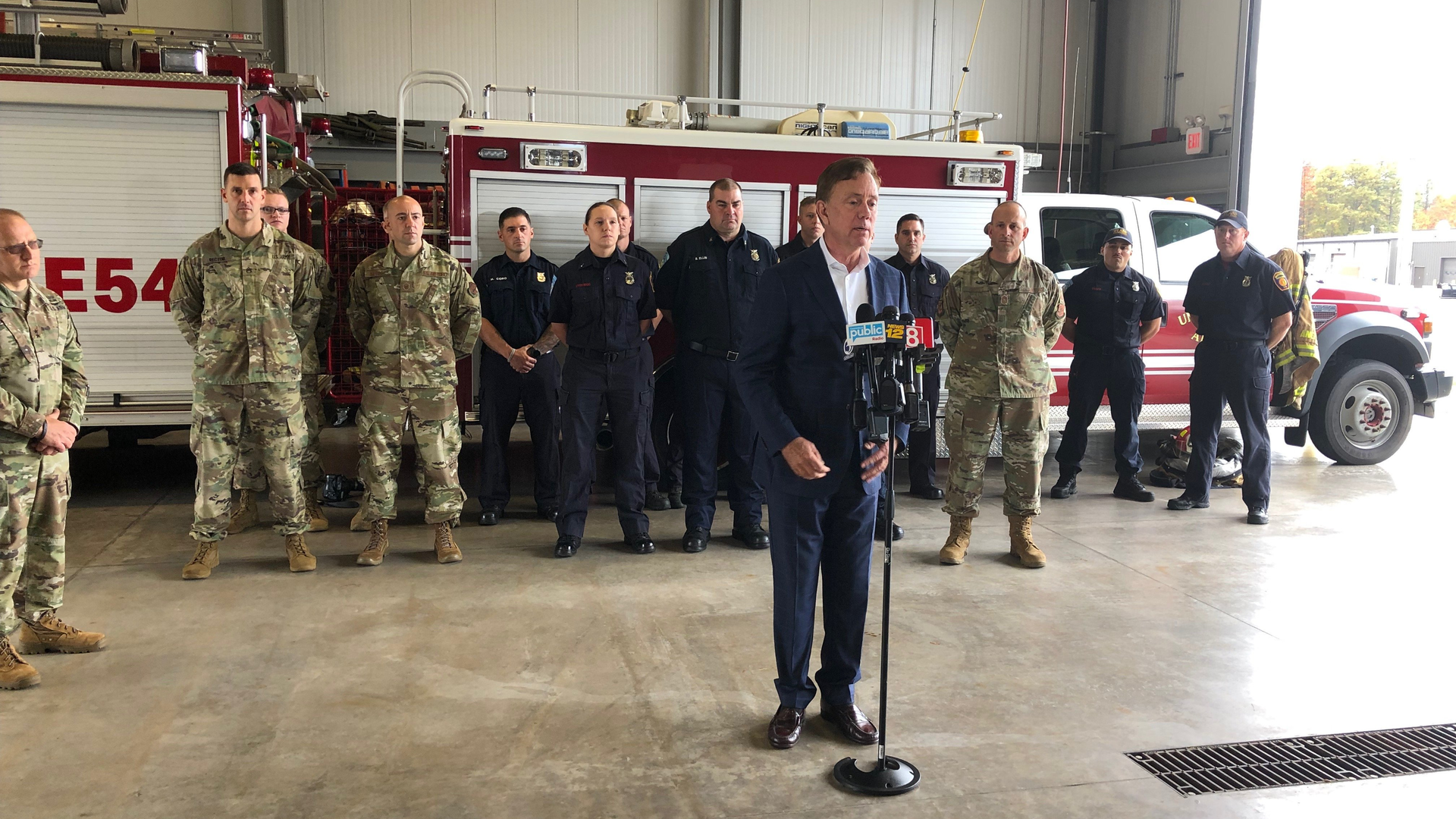 Connecticut Gov. Ned Lamont (center) thanks firefighters Wednesday for their response during the Oct. 2 crash of a World War II-era airplane at Bradley International Airport.