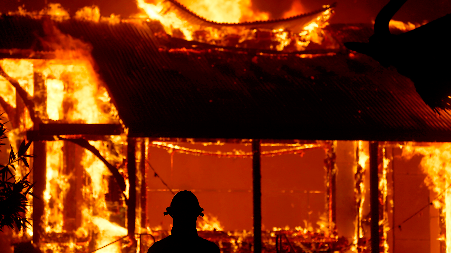 A firefighter watches the tasting room of the Soda Rock Winery be consumed by flames from the Kincade wildfire Oct. 27.