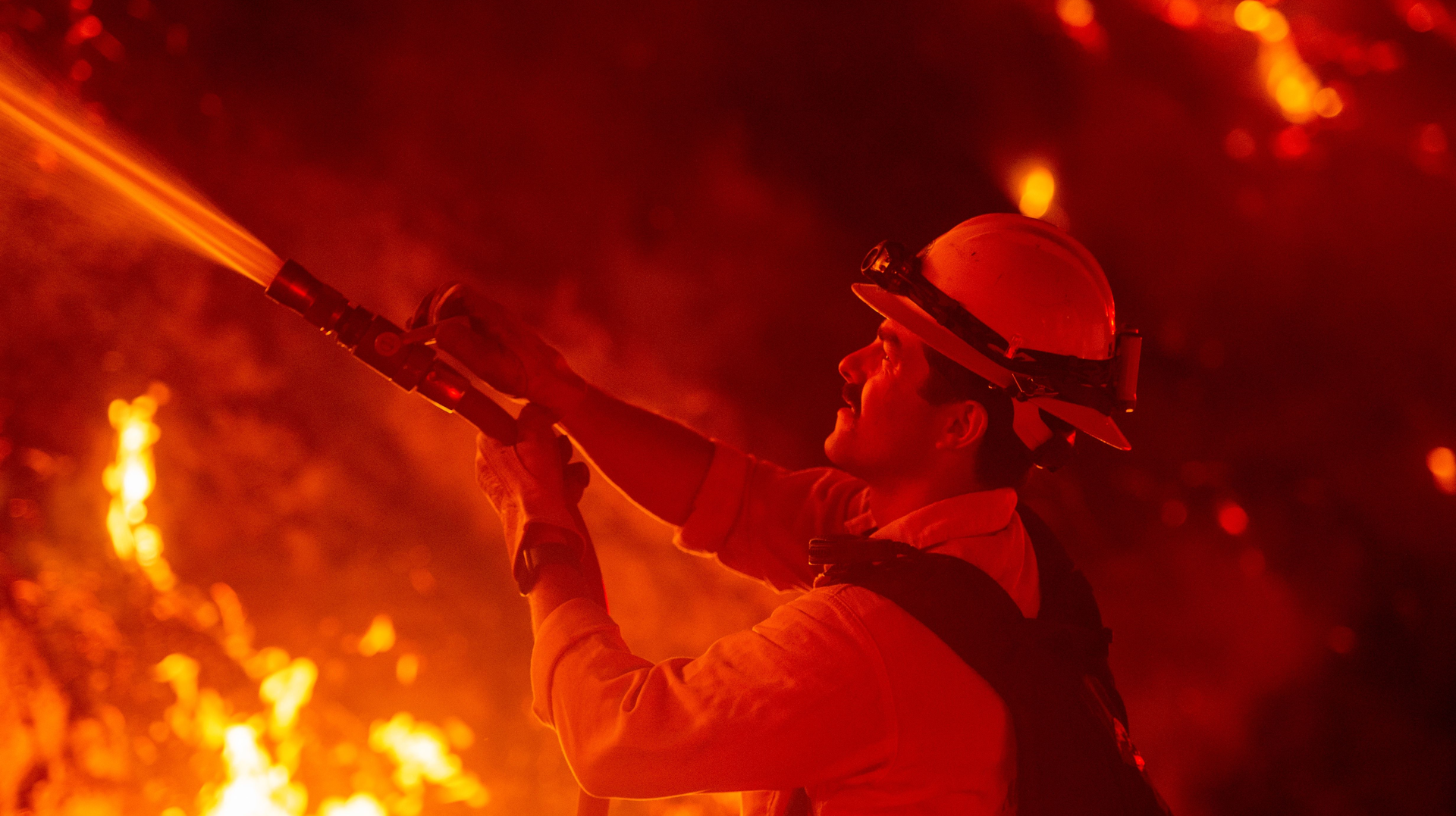 A firefighter douses flames from a backfire during the Maria fire Thursday in Santa Paula, CA.