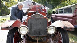 Retired Scituate, MA, firefighter Bob Quinlan looks over the 1924 White fire engine he and three other retired firefighters bought to restore.