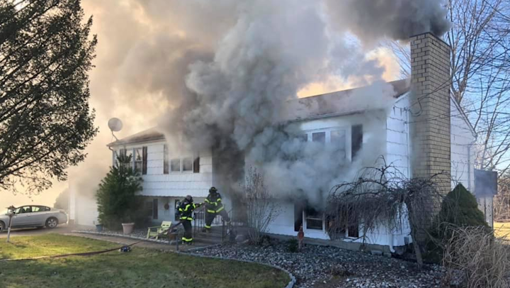 North Branford firefighters battle a house fire where a woman was removed after being trapped in the basement.
